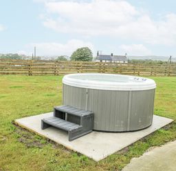 A hot tub with steps on a patio in outdoor space at The Old Cornmill in Cemaes Bay
