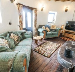 A living room with sofas and a television at The Old Cornmill in Cemaes Bay