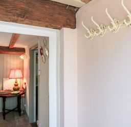 An entryway with a lamp and table at Old Farm Cottage in Warminster