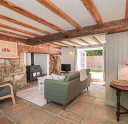 A living room with a fireplace and sofa at Old Farm Cottage Warminster