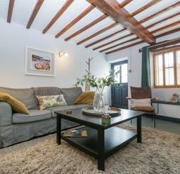 A living room with a sofa and coffee table at Elm Cottage in Moreton-In-Marsh