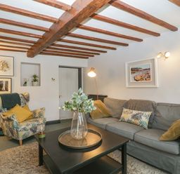 A living room with a sofa and armchair at Elm Cottage in Moreton-In-Marsh