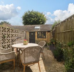 A garden with table and chairs at Elm Cottage in Moreton-In-Marsh