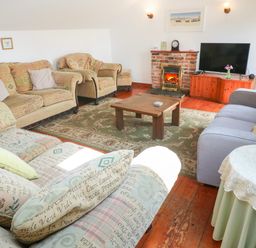 A living room with sofas and a television at The Cottage in St. Ives