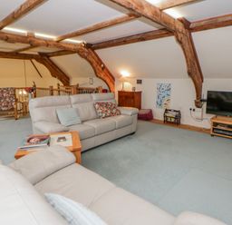 A living room with a sofa and television at Yr Hen Ysgoldy
