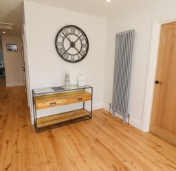 A hallway with a clock and console table at Rose Cottage in Dunstan near Embleton