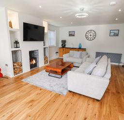 A living room with a television and a coffee table at Rose Cottage Dunstan near Embleton