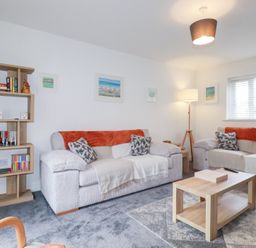 A living room with a bookshelf and sofas at Poldam St Austell