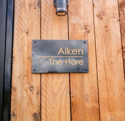 A sign on a wooden wall at Alken The Hare in Bushmills