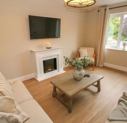 A living room with a television and fireplace at Hafan Y Gof Newcastle Emlyn