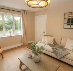 A living room with a sofa and coffee table at Hafan Y Gof, Newcastle Emlyn