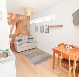 A living room with a sofa and dining table at Carn Brea Redruth
