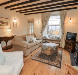 A living room with a sofa and television at Stoker’s Cottage in Bowness-On-Windermere