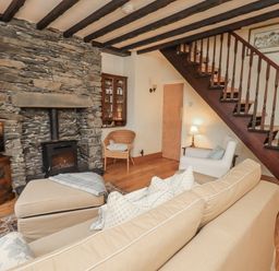 A living room with a sofa and fireplace at Stoker’s Cottage in Bowness-On-Windermere