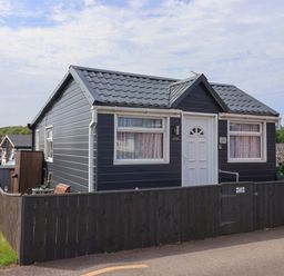 A cottage with a front door and windows at Sandbay in Bridlington