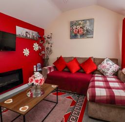 A living room with a television and sofa at Sandbay in Bridlington