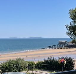 A beach view with a pier and boats at 10 Croft Court Tenby