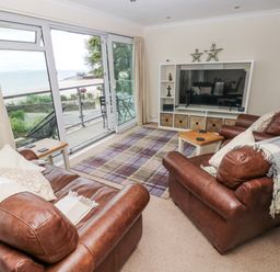 A living room with couches and a television at Lifeboat Lookout in Tenby