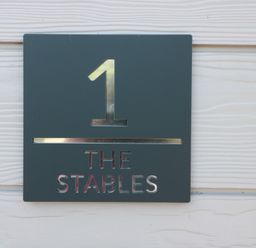 A sign displaying number 1 and the text THE STABLES at 1 The Stables Highbridge