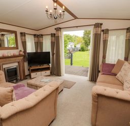 A living room with a sofa and television at 22 Yealand in Carnforth