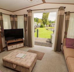 A living room with a television and sofa at 22 Yealand in Carnforth