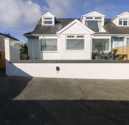 A house with patio area and chairs at Swn Y Don Llanbedrog