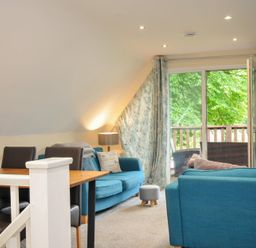 A living room with a sofa and dining table at Valley Lodge 2 Callington