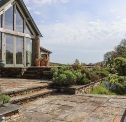 A garden with stone steps and planters at Lower Velwell Barn in Totnes