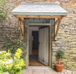 An entrance with a door and plants at Lower Velwell Barn in Totnes