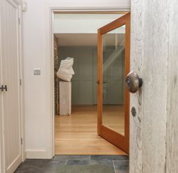 An entrance hall with a sculpture and mirror at Lower Velwell Barn in Totnes