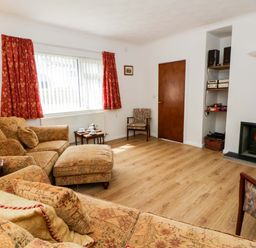 A living room with a sofa and fireplace at No.1 Vanderhoof Way in Saundersfoot