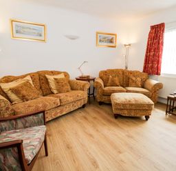 A living room with a sofa and armchair at No.1 Vanderhoof Way in Saundersfoot