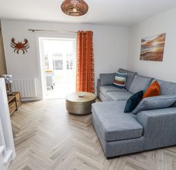 A living room with a sofa and coffee table at Seahorse Cottage in Chathill