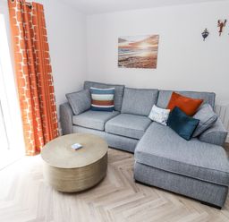 A living room with a sofa and a coffee table at Seahorse Cottage in Chathill