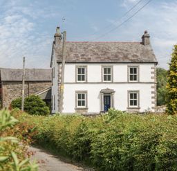 A house surrounded by trees and bushes at Grove House in Grange-Over-Sands