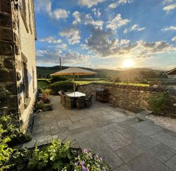 An outdoor seating area with a table and chairs at Grove House in Grange-Over-Sands
