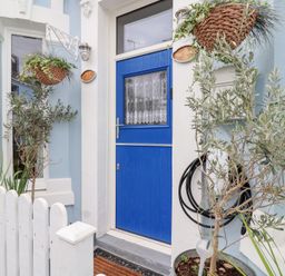 An entryway with a blue door and potted plants at Still Waters in Brixham