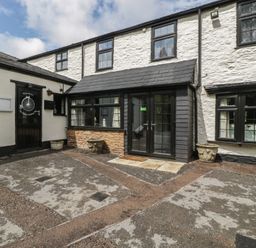 An outdoor entrance area with a path and planters at Penny Farthing Inn Aston Crews near Ross-On-Wye