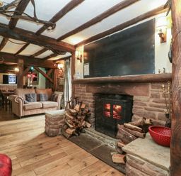 A living room with a fireplace and sofa at Penny Farthing Inn Aston Crews near Ross-On-Wye