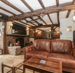 A snug area with a sofa and fireplace at Penny Farthing Inn Aston Crews near Ross-On-Wye