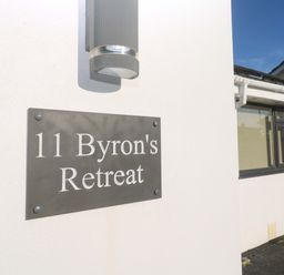 An exterior view of the sign for 11 Byron's Retreat in Crantock