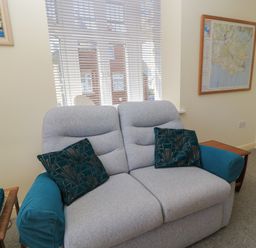 A living room with a sofa and a map on the wall at Purbeck Vista in Swanage