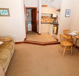A living room with a sofa and dining area at Hayloft in Ipswich