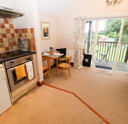 A kitchen with a table and chairs at Hayloft Ipswich
