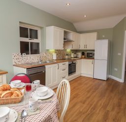 A kitchen with a dining table and appliances at Fisherman's Rest Ipswich