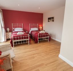 A bedroom with two beds and a chair at Fisherman's Rest in Ipswich