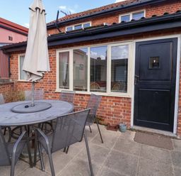 An outdoor dining area with a table and chairs at Coachman's Cottage in Ipswich
