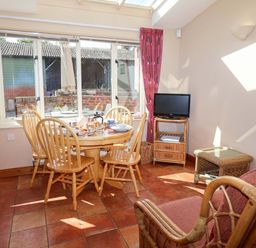 A dining room with a table and chairs at Coachman's Cottage, Ipswich