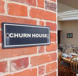 A house sign on a brick wall at Churn House in Ipswich