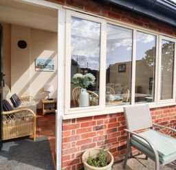 A sunroom with seating and a table at Churn House in Ipswich